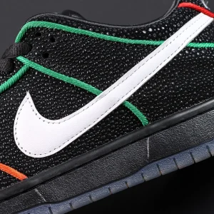 Detailed close-up of Bronx Girls Skate x Nike Dunk Low SB ‘Mel & Kava’ white leather Swoosh on black textured upper with green trim