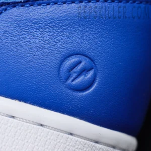 Extreme close-up of embossed Fragment Design lightning bolt on royal blue leather heel panel