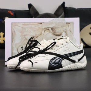 Rosé x Wmns Speedcat Premium ‘Warm White’ front angle with box in background highlighting design presentation