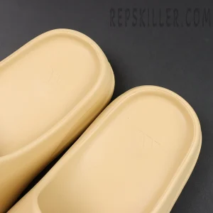 Yeezy Slides ‘Desert Sand’ Insole Close-Up Features the embossed adidas Three-Stripe logo with neat details.