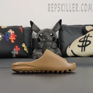 Front-side diagonal view of the adidas Yeezy Slides ‘Soot’ with plush background.