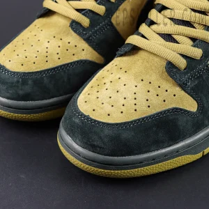 Nike Supreme x Dunk Low SB “Camper Green” toe box close-up highlighting dual-tone suede in moss green and tan with perforation details.