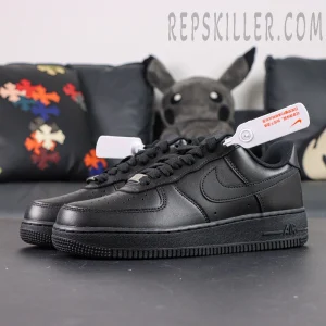 Angled front view of Nike Air Force 1 ’07 “Triple Black” showing smooth leather upper and lace tag detail.