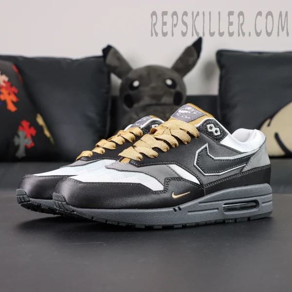 Three-quarter angle of Nike Air Max 1 “Low Poly - Big Head Mode” highlighting grey-white color blocking and reversed Swoosh logo.