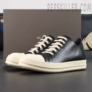 Rick Owens Hollywood Low “Black Milk” sneakers with box in background, featuring black leather upper and cream rubber sole.