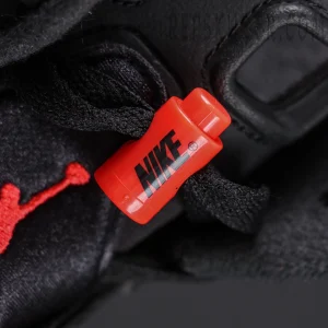 Jordan 6 “Reverse Infrared” Black / Light Crimson macro close-up of red lace lock with Nike logo.