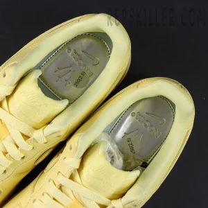 Overhead view of NOCTA x Nike Air Force 1 Low “Citron Tint” showing yellow leather upper and silver NOCTA insoles.
