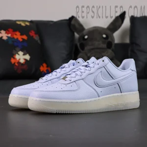 Angled front view of NOCTA x Nike Air Force 1 “Palest Purple” showing soft pastel purple tone and metallic lace tags.