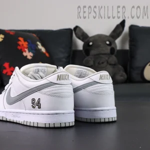 Nike Supreme x Dunk Low SB “White Metallic Silver” angled back view featuring silver swoosh and 94 embroidery on the heel.