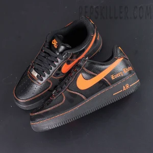 Top-down view of Vlone x NikeLab Air Force 1 “Vlone” showing both shoes with contrasting orange Swoosh logos.