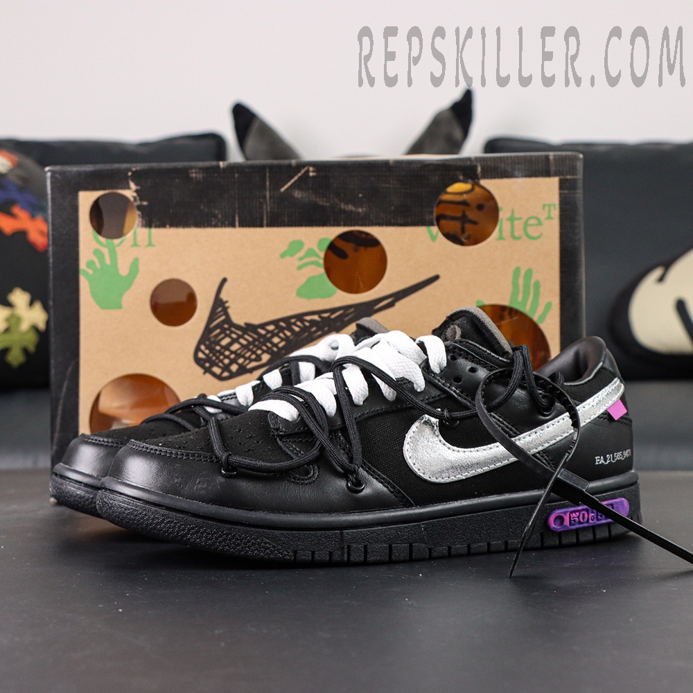 Off-White x Nike Dunk Low Lot 50 of 50 sneakers with black leather upper, metallic silver Swoosh and purple lot badge displayed in front of shoebox.
