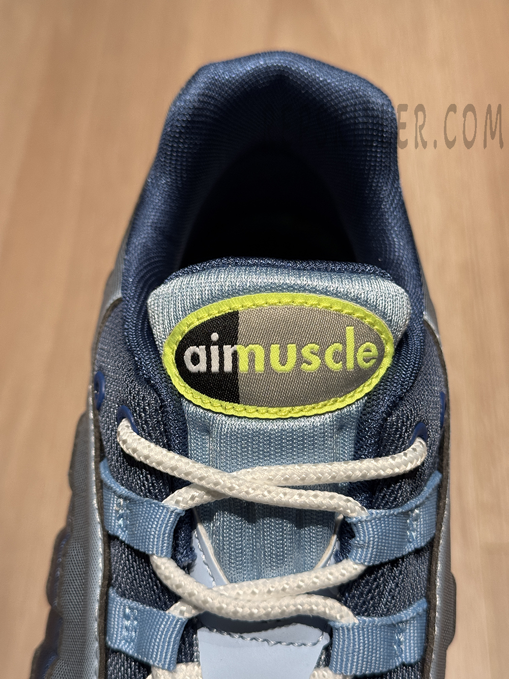 Close-up of the tongue label featuring the “airmuscle” logo in neon yellow and grey.