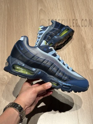 Hand-held side view of the Yu-Gi-Oh! x Air Max Muscle 95 QS “Joey” featuring blue gradient upper and neon green Air units.