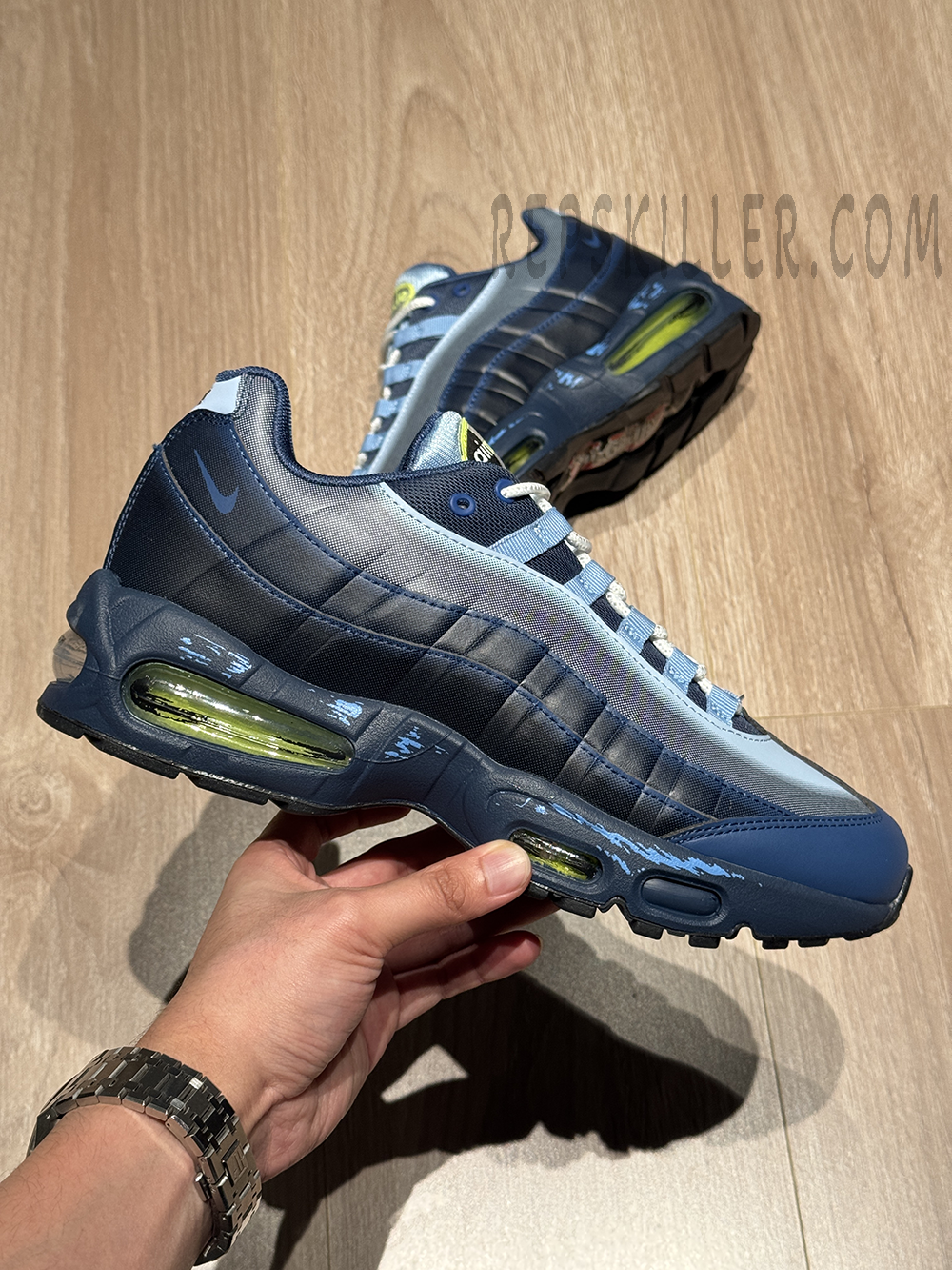 Hand-held side view of the Yu-Gi-Oh! x Air Max Muscle 95 QS “Joey” featuring blue gradient upper and neon green Air units.