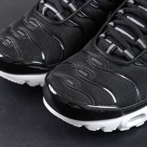 Close-up of Nike Air Max Plus Black White toe box with mesh upper and glossy black mudguard