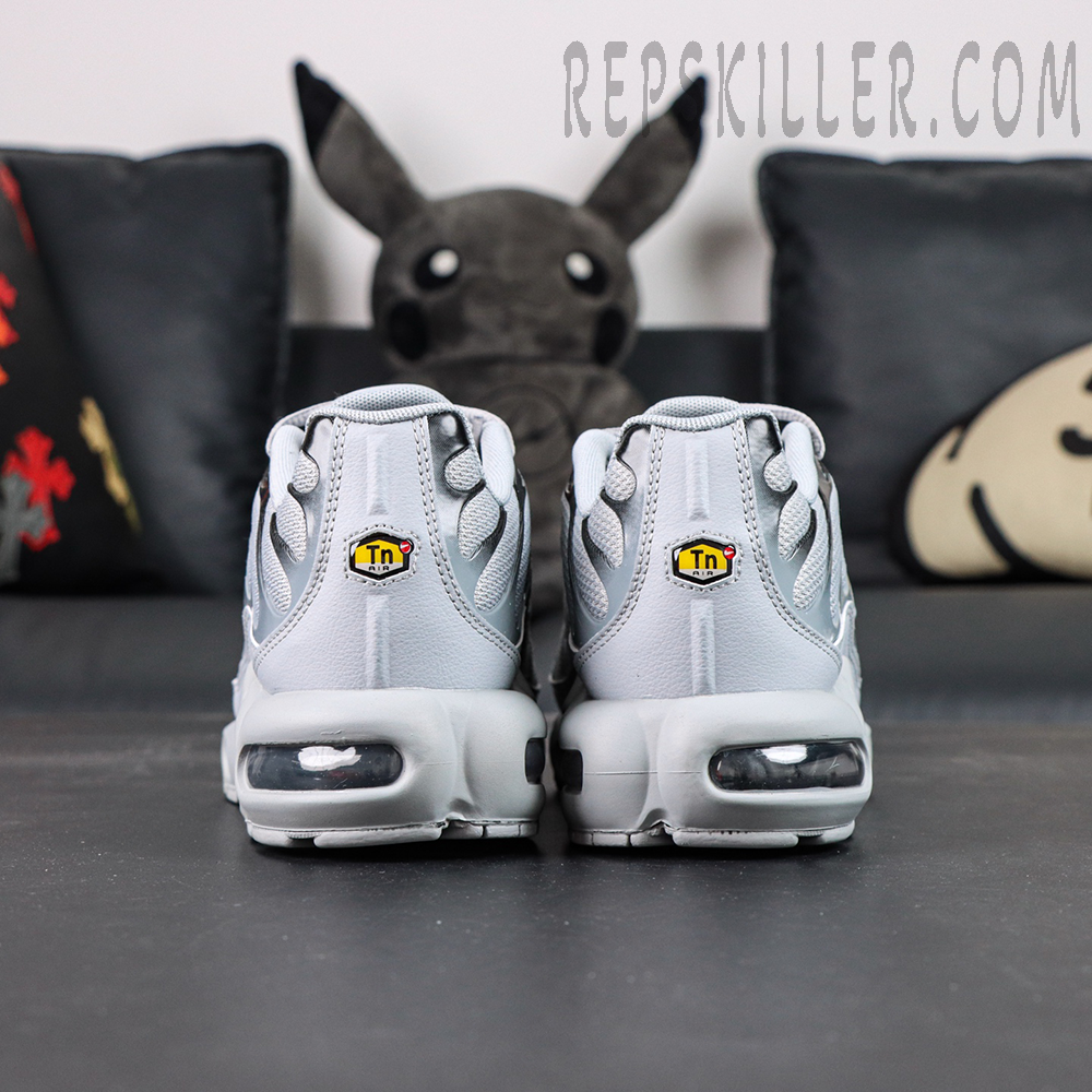 Back view of a pair of Nike Air Max Plus TN Wolf Grey sneakers showing symmetrical heel design