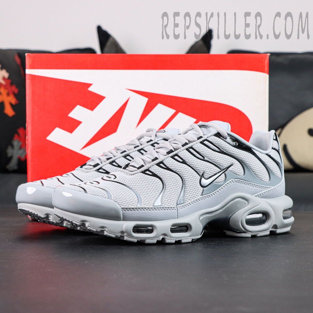 Nike Air Max Plus TN Wolf Grey displayed with original Nike shoebox in a lifestyle setting