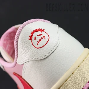 Travis Scott x Jordan 1 Low OG “Tropical Pink”, lateral heel close-up with embroidered smiley logo and white leather