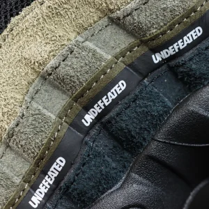 Undefeated x Nike Air Max 95 “Medium Olive” sneakers, layered side detail with repeated UNDEFEATED text branding
