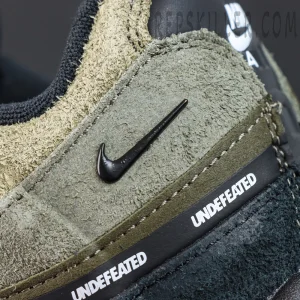 Undefeated x Nike Air Max 95 “Medium Olive” sneakers, lateral detail with repeated UNDEFEATED text and mini Swoosh