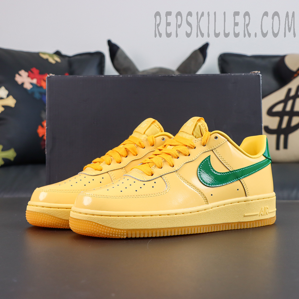 Nike Air Force 1 Low “Patent Leather Topaz Gold” full sneaker display featuring glossy yellow upper, green Swoosh, and orange-yellow laces