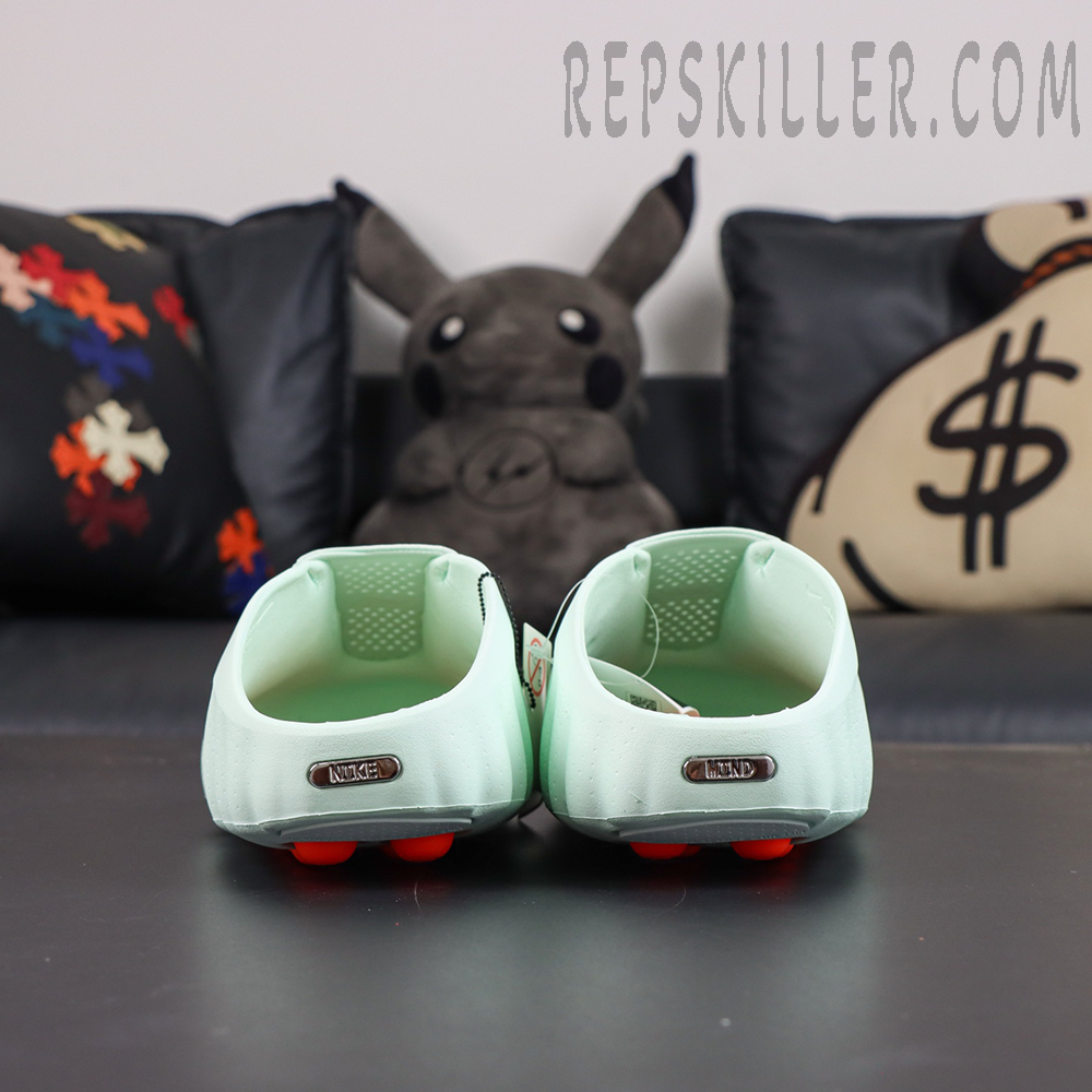 Nike Mind 001 “Barely Green” heel view featuring metallic branding plaques and a supportive wraparound heel structure