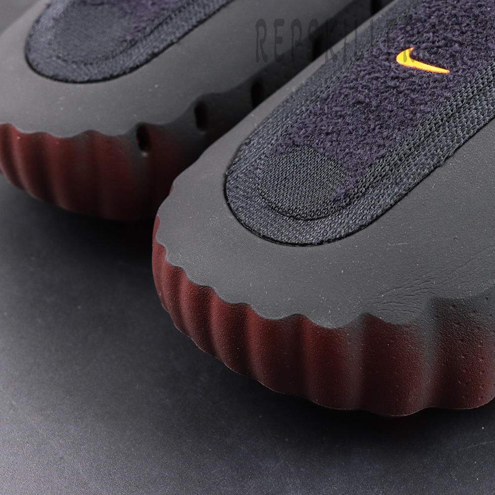 Nike Mind 001 Flyknit “Bronze Eclipse” upper detail featuring textured fabric panels and a bright orange Swoosh logo