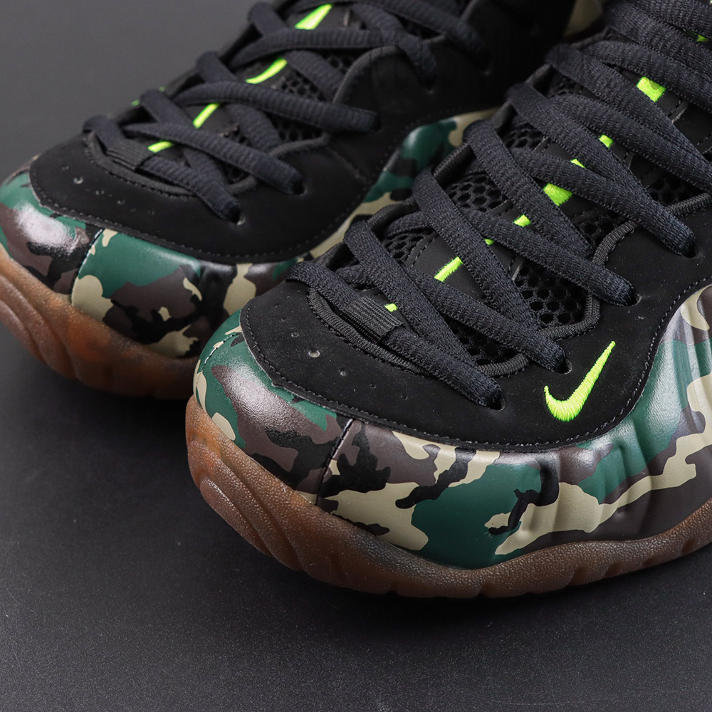 Nike Air Foamposite Pro ‘Green Camo’ toe box close-up featuring camouflage Foamposite shell, black lacing system and neon green embroidered Swoosh