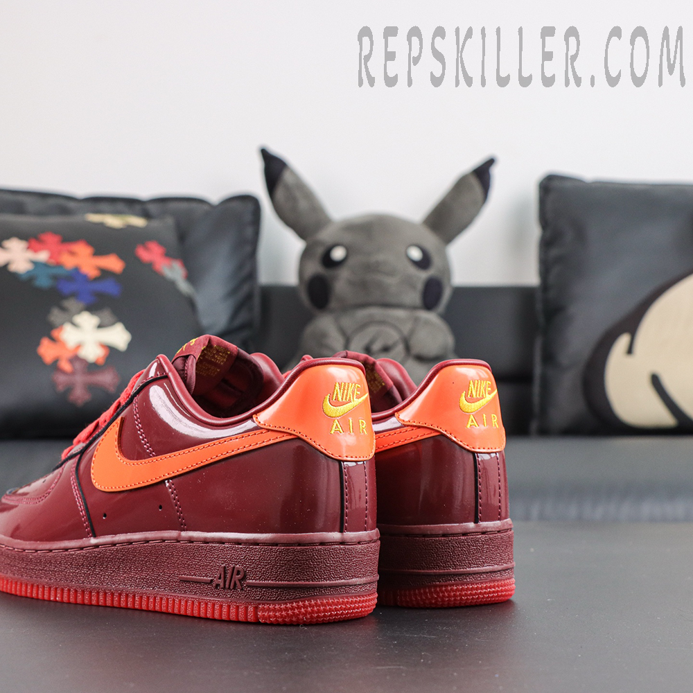 Nike Air Force 1 Low ‘Patent Leather Dark Team Red’ heel view featuring dark red patent leather, orange heel tabs and embroidered Nike Air branding