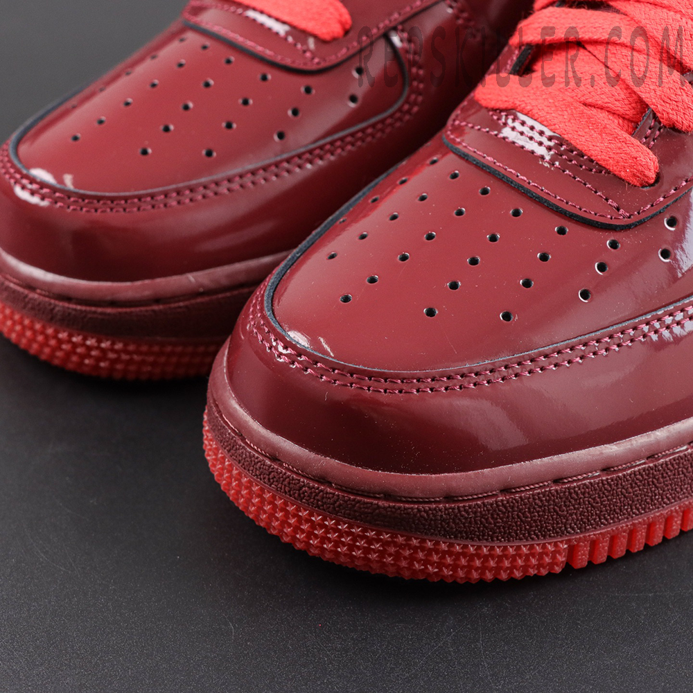 Nike Air Force 1 Low ‘Patent Leather Dark Team Red’ toe close-up featuring a dark team red patent leather upper, perforated detailing and red rubber outsole