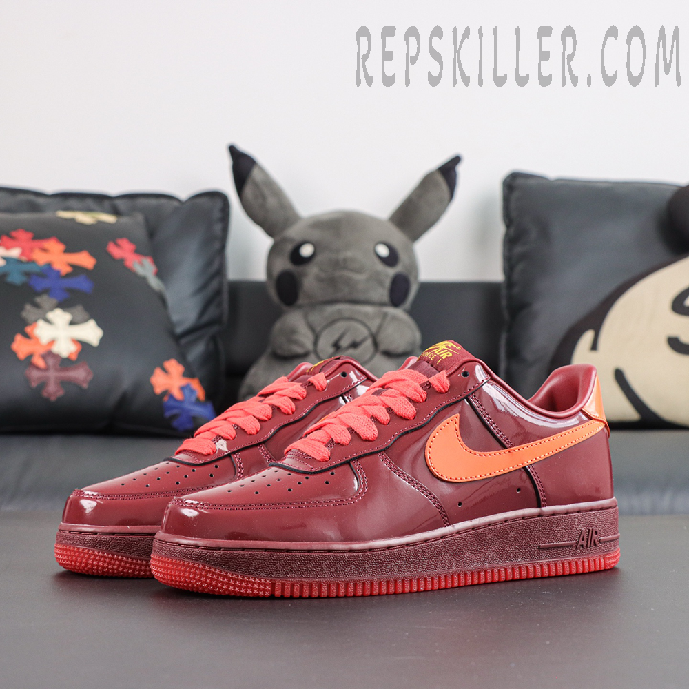 Nike Air Force 1 Low ‘Patent Leather Dark Team Red’ side profile featuring a burgundy patent leather upper with orange Swoosh branding