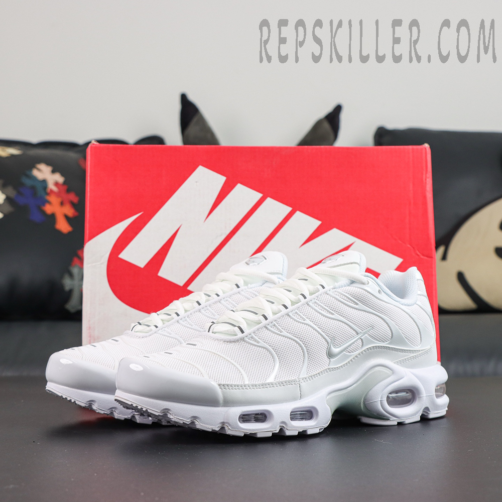 Nike Air Max Plus ‘Triple White’ pair angle view featuring white mesh, silver-white TPU wave overlays, and a tonal midsole