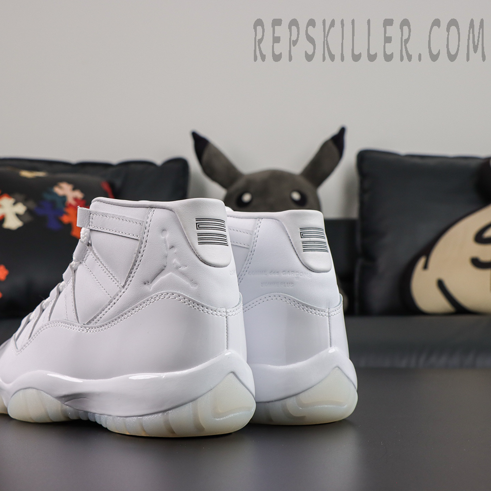 Comme des Garçons x Air Jordan 11 Retro ‘White’ rear angle view featuring embossed Jumpman branding, collaboration text, white patent leather, and translucent icy outsole