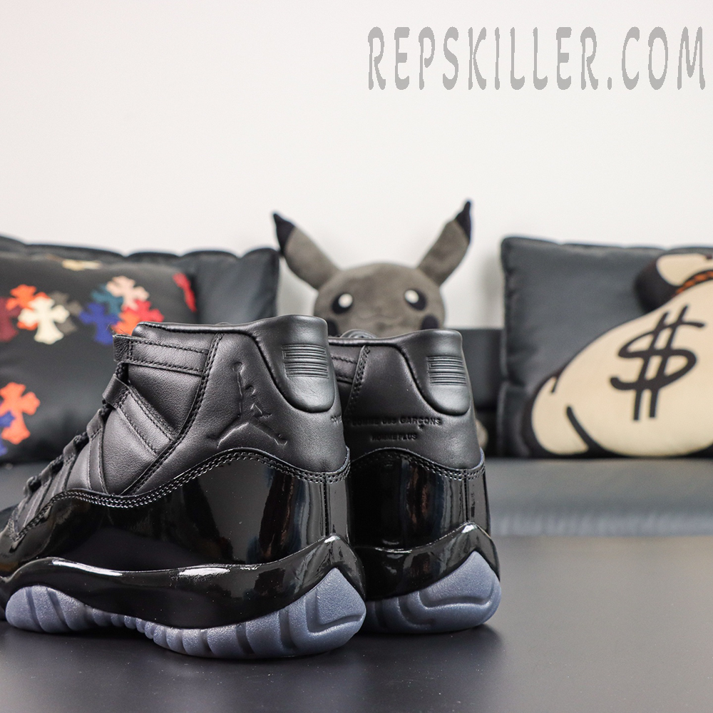 Comme des Garçons x Air Jordan 11 Retro ‘Black’ rear angle close-up highlighting the leather collar, embossed Jumpman, collaboration text, patent leather heel, and icy grey outsole